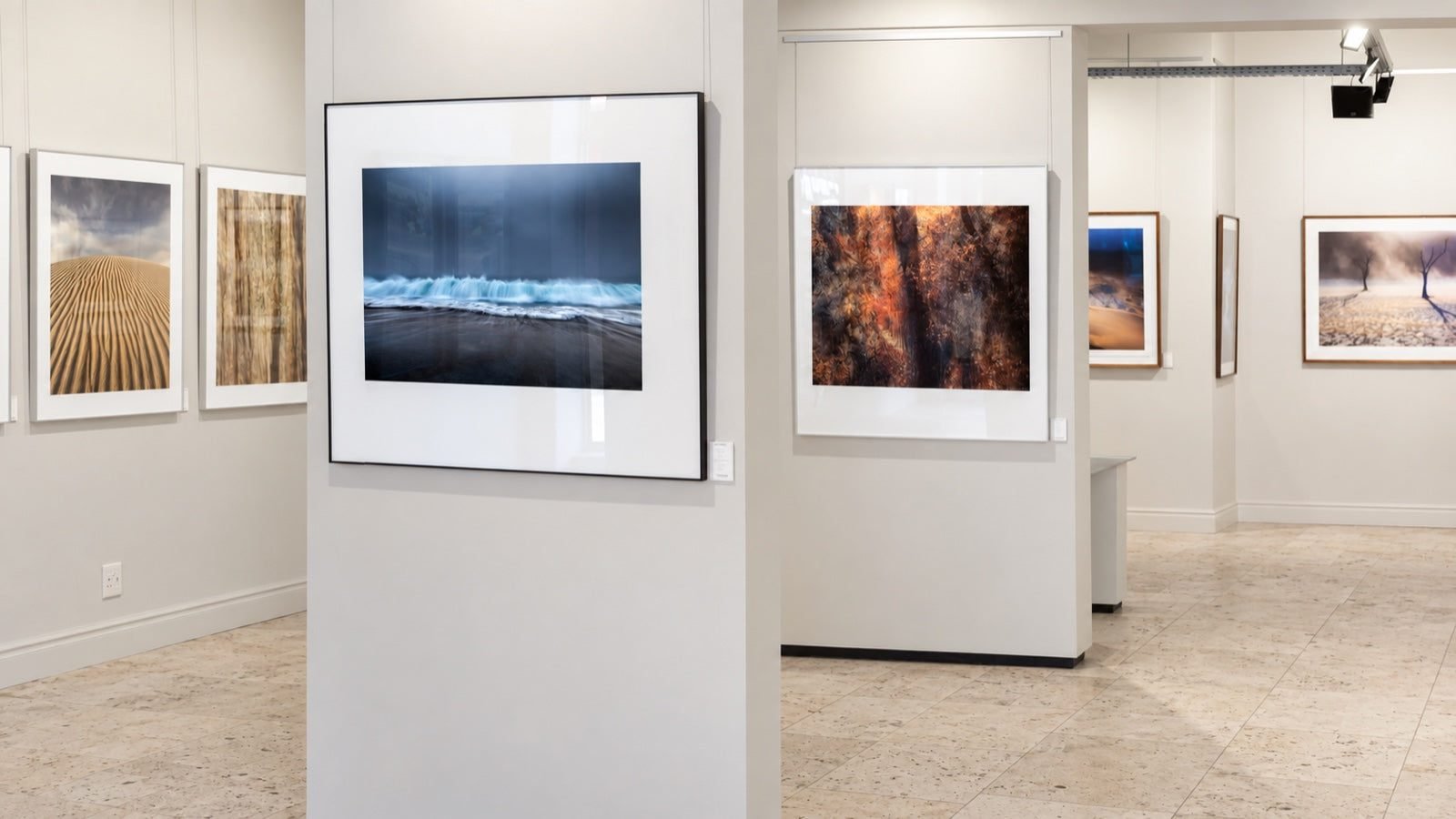 Framed landscape photographs in white mounts and slim black frames at Osner Gallery